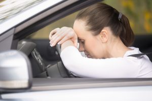 Mujer cansada con cabeza sobre el volante