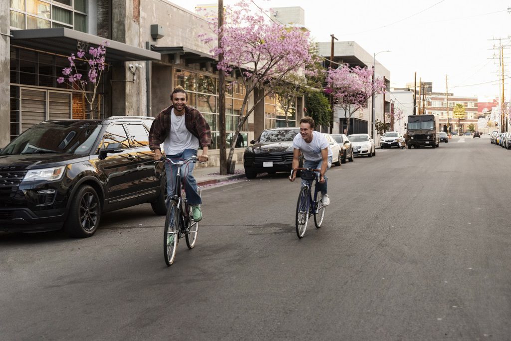 Dos chicos montando en bicicleta por la ciudad