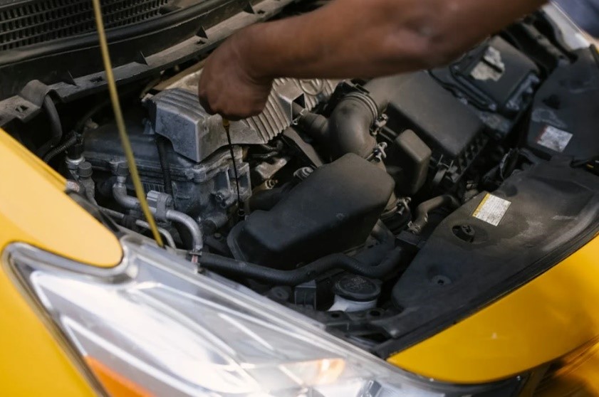 Hombre revisando el motor de un coche